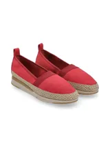Slip-on de cuero color rojo, estilo alpargata, con detalle de cordón rústico trenzado ornamental alrededor de la base y suela deportiva flexible en tono beige.