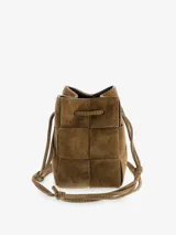 Cartera tipo bucket de gamuza color marrón con diseño trenzado, cierre con lazo ajustable y correa larga para llevar cruzada.