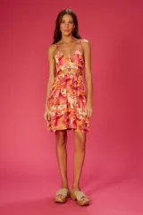 Vestido corto con estampado tropical en tonos rosados, amarillos y naranjas. Tiene breteles finos, escote en V y abertura en la cintura.