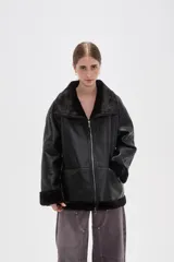 Campera de cuero sintético con interior y detalles de piel sintética en cuello, puños y ruedo. Presenta cierre frontal completo y diseño de corte holgado.