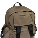 Mochila Adidas color marrón con diseño utilitario, cuenta con múltiples compartimentos, cierres frontales con hebillas negras y logo del trébol bordado en la parte inferior.