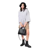 Poncho de tejido de punto en color gris, con textura acanalada diagonal y cuello alto.