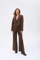 Pantalón de cuero ovino con diseño de corte ancho y estilo sastrero, con costuras verticales que definen su estructura.