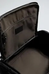 Mochila deportiva de diseño minimalista fabricada en tejido técnico resistente. Cuenta con compartimento principal con cierre de cremallera, bolsillo frontal con cierre, interior con bolsillo organizador, parte posterior acolchada con banda de sujeción para equipaje, asa superior y correas de hombro ajustables.