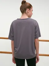 Remera deportiva blanca de manga corta, cuello redondo y corte oversized con tecnología dry fit.
