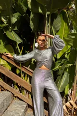 Pantalón de tiro alto confeccionado en tejido de lamé dorado con acabado brillante y corte ligeramente evasé.