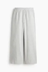 Pantalón deportivo gris claro de corte ancho, con cintura elástica y bolsillos laterales.