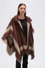 Poncho de tejido grueso, color negro y gris, con diseño de franjas diagonales y cuello alto con cierre. Presenta terminaciones con flecos.