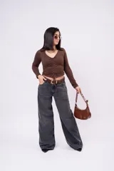 Jean wide-leg de tiro bajo, color gris carbón deslavado, con diseño amplio y fluido, bolsillos laterales y traseros clásicos.
