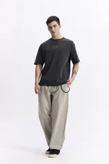 Remera de manga corta color gris oscuro, con escote redondo y estampado frontal con la frase "Immortal Dreams" en blanco.