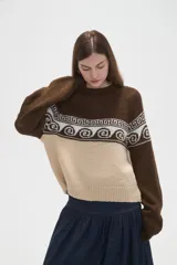 Sweater de tejido de punto con diseño jacquard, cuello redondo y mangas largas. Presenta una combinación de bloques de color azul marino y celeste con un patrón geométrico en la parte superior.