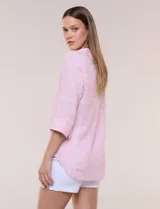 Blusa de silueta relajada con textura tramada, color azul con rayas verticales en tonos rosados, celestes y amarillos. Cuenta con cuello mao abierto en V y mangas tres cuartos amplias con pequeña abertura lateral en el puño.