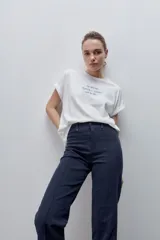 Pantalón de jean azul marino, de tiro alto y calce ajustado con pierna recta levemente amplia, bolsillos traseros y recortes verticales en el delantero.