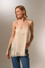 Musculosa de poliamida color negro, con breteles finos, escote profundo y detalles de encaje en el escote y el ruedo. Presenta un diseño holgado.