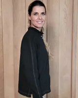 Camisa de manga larga con estampado de rayas verticales en tonos crudo y beige. Presenta cuello alto con volados, cierre frontal con botones dobles y puños con volados.