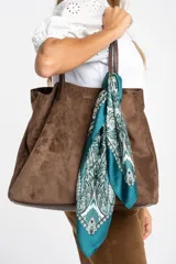 Pañuelo tipo bandana de forma cuadrada con estampado geométrico y floral en tonos verde petróleo, blanco y negro. Presenta bordes definidos y un acabado suave y ligero.