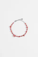 Pulsera de acero quirúrgico con abalorios de cuentas rojas facetadas y piedras en bruto, acompañada de una cadena de eslabones con cierre ajustable.