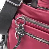 Bandolera de tela color bordó con detalles en negro, cuenta con doble asa de mano, correa ajustable extraíble, cierre principal y bolsillo frontal con cierre, además de un detalle de cordón decorativo y logo circular metálico en el frente.