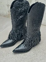 Bucaneras negras de cuero con caña alta y flecos desmontables.