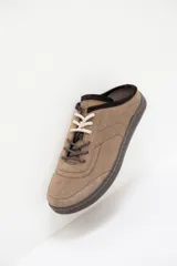 Zuecos de cuero negro con diseño tipo sneaker, cordones y suela de goma color caramelo. Presentan detalle de marca Petra en la lengüeta.