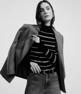 Suéter de punto negro con rayas horizontales blancas, cuello alto y mangas largas.