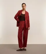 Pantalón de vestir color borgoña, de corte zanahoria, con pliegues delanteros, cierre con solapa y cremallera oculta.