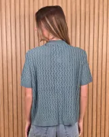 Cardigan calado de manga corta, tejido en punto con cierre frontal de botones y cuello redondo.