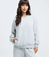 Buzo femenino de cuello redondo y manga larga, confeccionado en tejido de algodón con felpa. Presenta un diseño básico sin estampado, con puños y ruedo ajustados en tejido rib.