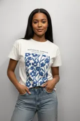 Remera de algodón de manga corta y cuello redondo, con estampado floral en color azul sobre fondo blanco.