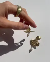 Aros colgantes de bronce dorado con diseño orgánico y perla de río natural en el extremo inferior.