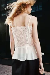 Top de encaje color crudo con escote recto y breteles finos ajustables. Modelo entallado con peplum levemente acampanado en tejido con brillo sutil.