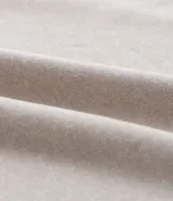 Remera deportiva de hombre con tecnología dry fit, cuello redondo y manga corta. Presenta un diseño liso en color beige con una pequeña etiqueta decorativa en el dobladillo.