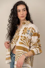 Camisa de manga larga de corte holgado, color blanco con estampado abstracto y floral en tonos ocre y azul.