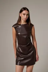 Vestido mini de eco-cuero color marrón, al cuerpo, con cuello a la base y detalles de frunces en los laterales.