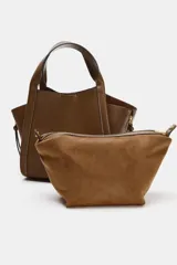 Bolso bandolera de formato city color marrón, con diseño estructurado, pespuntes decorativos, doble asa de mano y cremalleras laterales con tiradores colgantes.