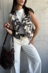 Chaleco con estampado de vaca, cuello en V y botones metálicos.