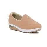 Zapato casual tipo slip-on color beige, con diseño acolchado, suela de plataforma blanca con cámara de aire y detalle de logo metálico circular en el empeine.