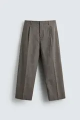 Pantalón de corte relajado con diseño de cuadros, confeccionado en tejido con lana. Presenta cintura con pliegues frontales, bolsillos laterales y bolsillos traseros de vivo, con cierre frontal de cremallera y gancho metálico oculto.