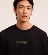 Remera negra de algodón, corte boxy, con cuello redondo y mangas cortas. Estampa frontal con el logo de Guns N' Roses en color dorado.