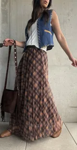Falda larga plisada con estampado de cuadros en tonos camel y marrón, confeccionada en tejido liviano con cintura elástica.