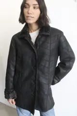 Campera de napalán de cuero genuino en color negro, con diseño de paneles horizontales y forro interior de piel sintética visible en cuello y puños. Cuenta con cierre frontal de botones.