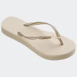Ojotas Havaianas modelo Slim Flatform, color beige claro, con tiras finas metalizadas doradas y suela ligeramente elevada.