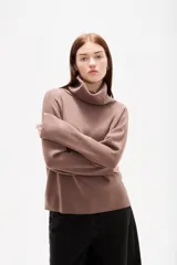 Polera de punto color camel, con cuello alto holgado y mangas largas de diseño amplio.