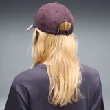 Gorra tipo dad cap Puma modelo Ess Elevated, con diseño de corona en tono bordó oscuro y visera curva en color beige claro. Cuenta con el logo bordado de la marca en el lateral frontal.