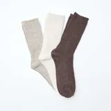 Pack de tres pares de medias de caña alta con diseño de canalé, en tonos neutros: gris, crema y marrón.