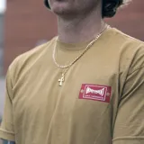 Remera color marrón claro con logo de Etnies en el cuello y estampado del logo de Independent en el pecho.