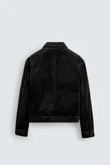Sobrecamisa de corte cropped confeccionada en terciopelo con elasticidad. Presenta cuello solapa, cierre frontal con cremallera metálica, bolsillos de vivo en la cadera y mangas largas con puños abotonados.