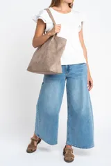 Remera negra de viscosa y elastano, con escote redondo y mangas cortas con volado de tela perforada (broderie).