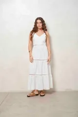 Vestido largo beige con tirantes finos, escote en V y detalles de inserciones de encaje broderie en la cintura y en la falda escalonada.