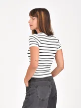 Remera de corte ajustado y manga corta, con diseño de rayas horizontales negras sobre fondo blanco y cuello redondo.